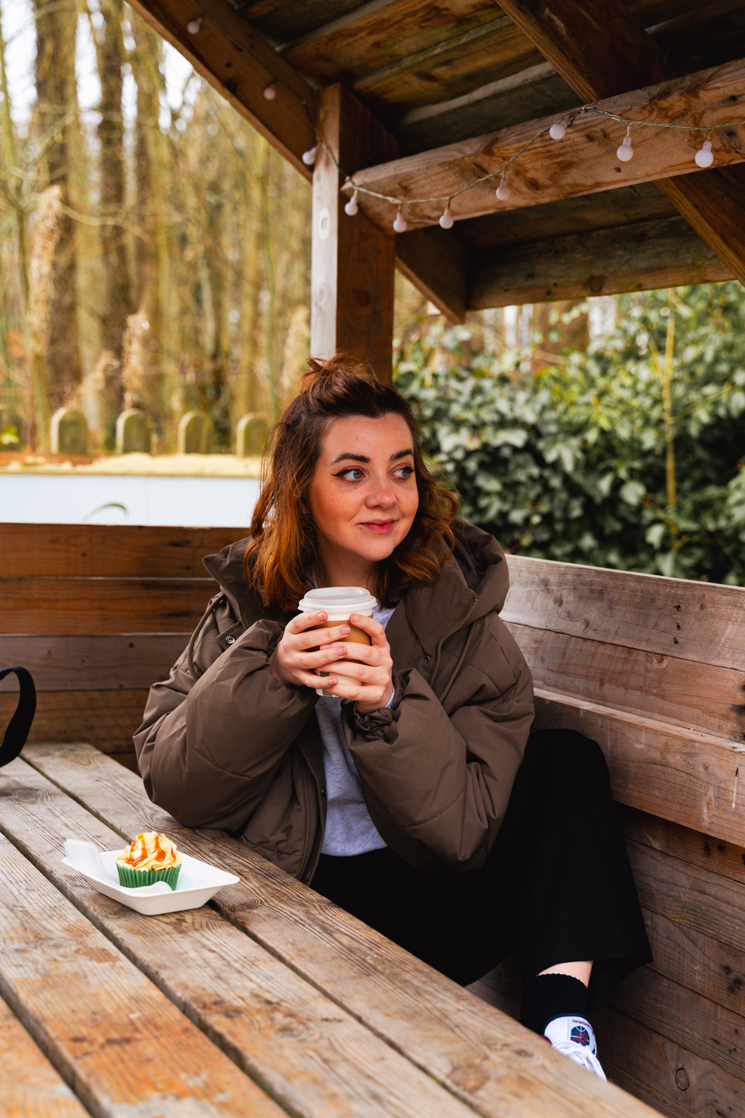 Lauren drinking a coffee with some cake at Haddo House